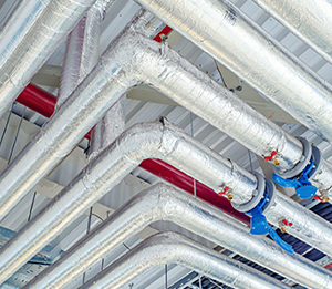 Travaux de calorifugeage par Isobat sur un réseau de tuyauterie hydraulique avec finition en tôle aluminium haute performance.